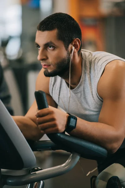 Handsome Young Man Working Out Stationary Bicycle Gym — Free Stock Photo