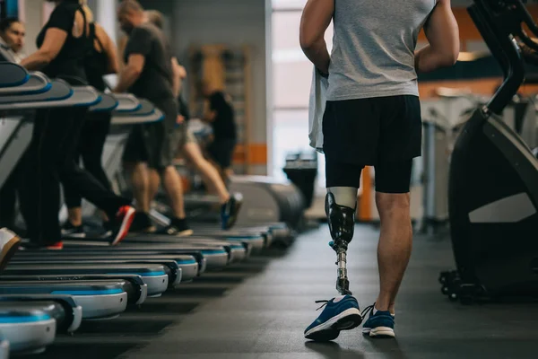 运动运动员的裁剪镜头与人工腿走在健身房 — 图库照片