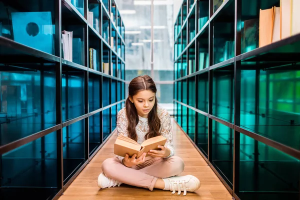 Adorable Concentrated Schoolgirl Reading Book Floor Library — Stock Photo, Image