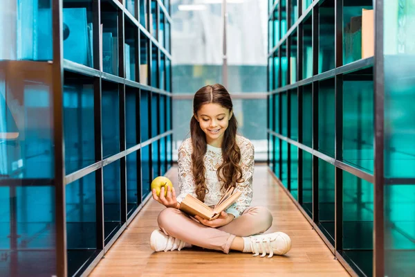 Beautiful Happy Schoolchild Holding Apple Reading Book Library — Stock Photo, Image