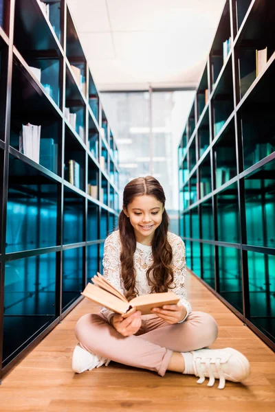 Mooie Lachende Schoolmeisje Zittend Vloer Leesboek Bibliotheek — Stockfoto