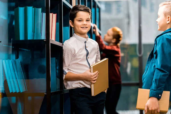 Söta Leende Skolbarn Hålla Böcker Medan Studera Biblioteket — Stockfoto