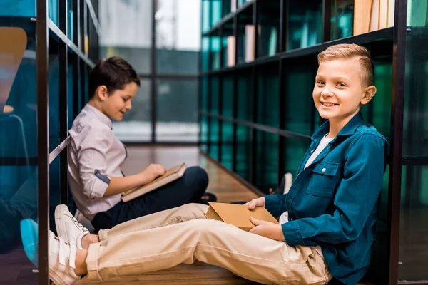 Sidovy Söt Leende Skolpojkar Läsa Böcker Medan Sitter Golvet Biblioteket — Stockfoto