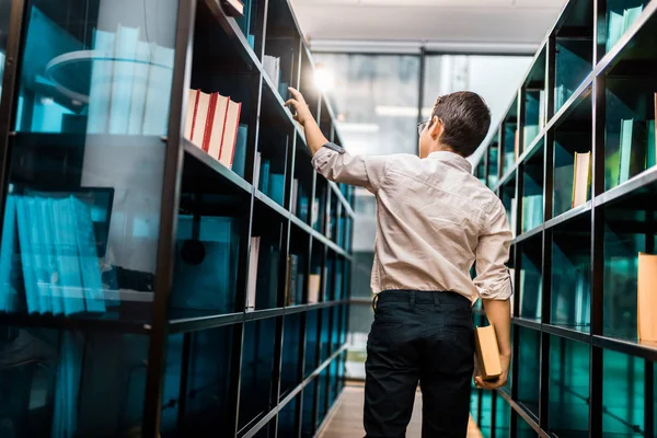 Back View Boy Holding Book Looking Bookshelves Library Stock Image