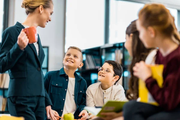 Smiling Librarian Looking Cute Schoolchildren Library — Stock Photo, Image