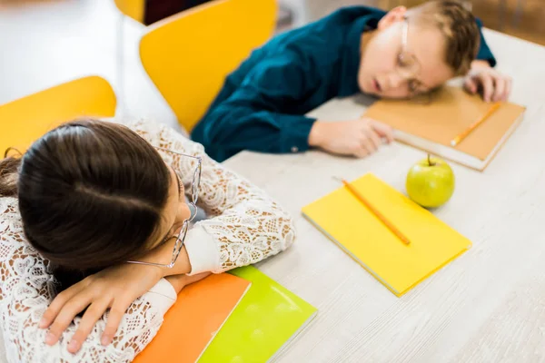 Visão Alto Ângulo Alunos Cansados Óculos Dormindo Mesa Com Livros — Fotografia de Stock