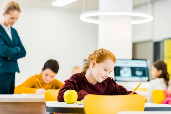 Teacher Looking Adorable Schoolchildren Writing Studying Desks — Stock Photo, Image