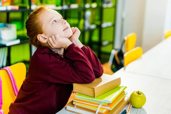 Urocza Uczennica Siedzi Przy Biurku Książek Patrząc Bibliotece — Zdjęcie stockowe