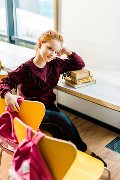 Vista Ángulo Alto Hermoso Colegial Sentado Escritorio Con Libros Sonriendo — Foto de stock gratis