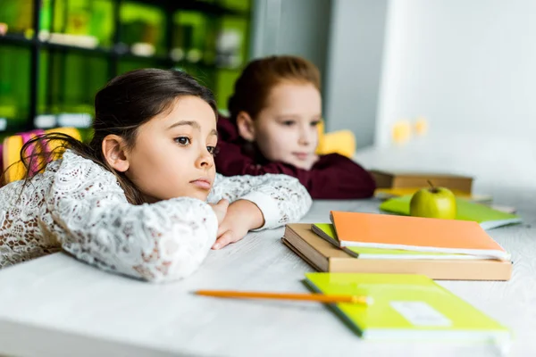 Verveeld Schoolmeisjes Leunend Bureau Met Boeken Zoek Weg Bibliotheek — Stockfoto