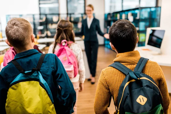 Visão Traseira Escolares Com Mochilas Olhando Para Bibliotecário Biblioteca — Fotografia de Stock