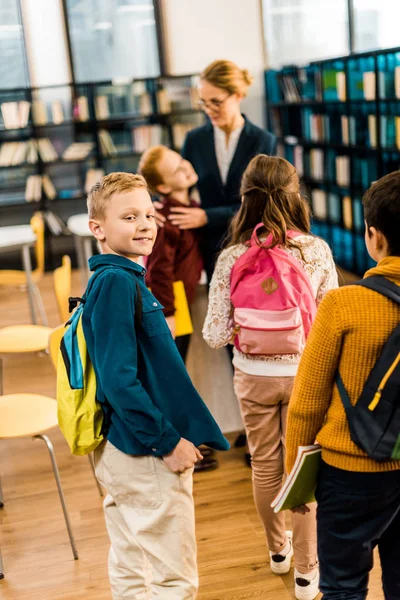 Vista Posterior Los Escolares Con Mochilas Pie Con Bibliotecario Biblioteca — Foto de Stock