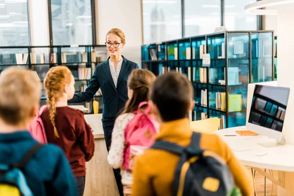 Kembali Melihat Anak Anak Sekolah Dengan Ransel Melihat Pustakawan Perempuan Stok Gambar Bebas Royalti