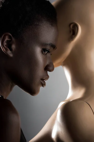 Портрет красивої молодої афроамериканки, що стоїть поруч з манекеном на чорному — стокове фото