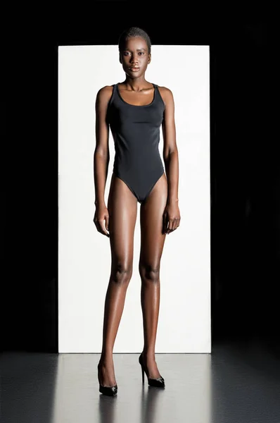 Visão de comprimento total da bela jovem africana americana em bodysuit e sapatos de salto alto olhando para a câmera — Fotografia de Stock