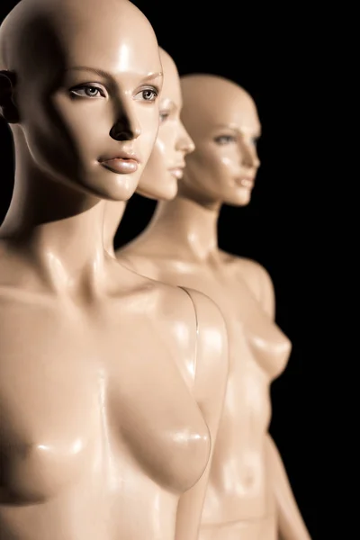 Close-up view of naked bald mannequins on black, selective focus — Stock Photo