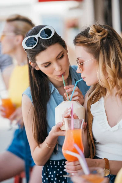 Hermosas novias jóvenes beber cóctel de verano juntos en el bar de la playa - foto de stock