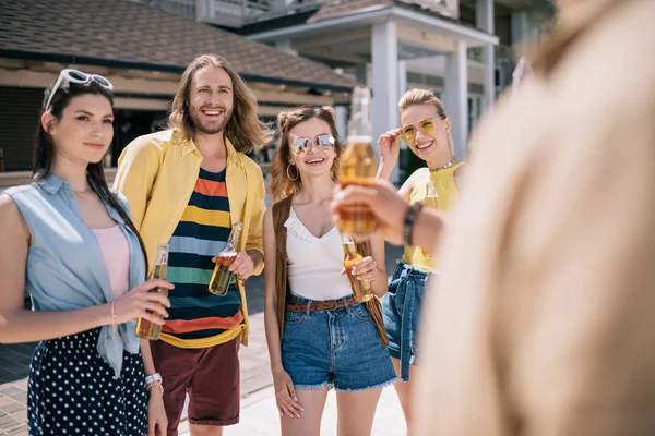 Selective focus of smiling young people drinking beer at beach bar — Stock Photo