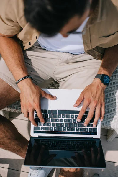 Top view of young man using laptop with blank screen outdoors — Stock Photo