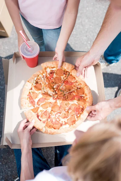 Tiro cortado da família com a filha tomando fatias de pizza — Fotografia de Stock