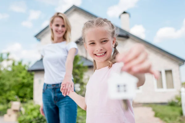 Happy little child holding hand of mother and showing key from their new house — Stock Photo