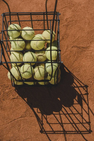 High angle view of basket of tennis balls standing on court — Stock Photo