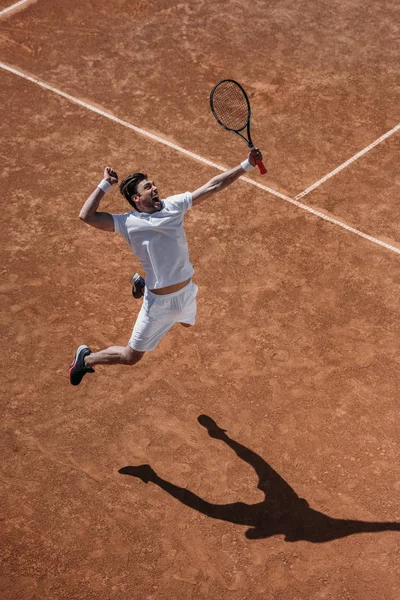 Hochwinkelaufnahme eines athletischen Tennisspielers, der beim Sprung einen Treffer macht — Stockfoto