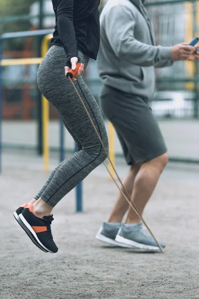 Imagen recortada de deportista y deportista saltar cuerdas - foto de stock