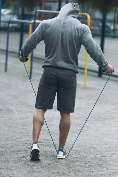 Rear view of sportsman jumping rope at sports ground — Stock Photo