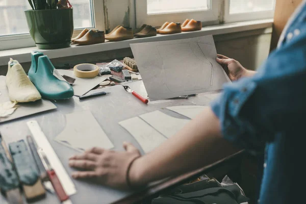 Cropped shot of shoemaker drawing outline for shoes at workshop — Stock Photo