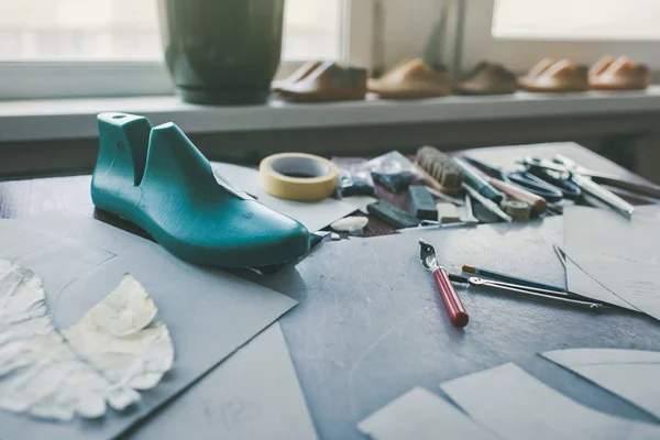 Verschiedene Werkzeuge und Schuhe zuletzt am Schuhmacherarbeitsplatz — Stockfoto