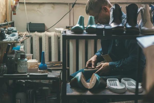 Experienced shoemaker creating shoes in workshop — Stock Photo
