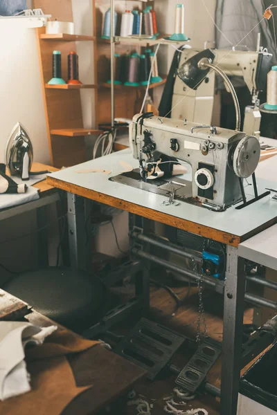 Workplace of seamstress at tailor shop with electrical industrial sewing machine — Stock Photo