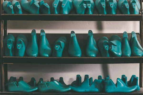 Rows of various shoe lasts on shelves — Stock Photo