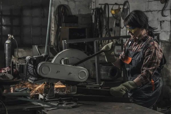 Female welder in protective googles using welding torch in workshop — Stock Photo