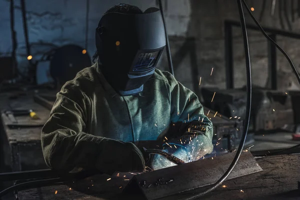 Operaio manuale in casco protettivo con torcia saldante operante in officina — Foto stock