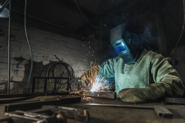 Operaio manuale in casco protettivo con torcia saldante operante in officina — Foto stock