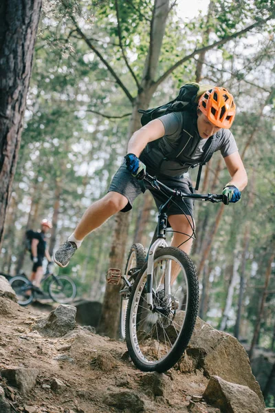 Bello giovane biker prova equitazione a bella foresta — Foto stock