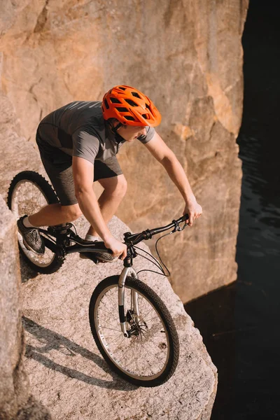 Blick aus der Vogelperspektive auf junge Trial-Biker, die im Freien auf Felsen balancieren — Stockfoto