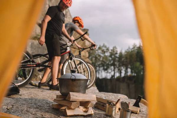 View of young trial bikers on rocky cliff outdoors from camping tent — Stock Photo