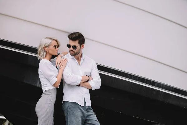 Beau jeune couple élégant dans des lunettes de soleil debout ensemble sur le yacht — Photo de stock