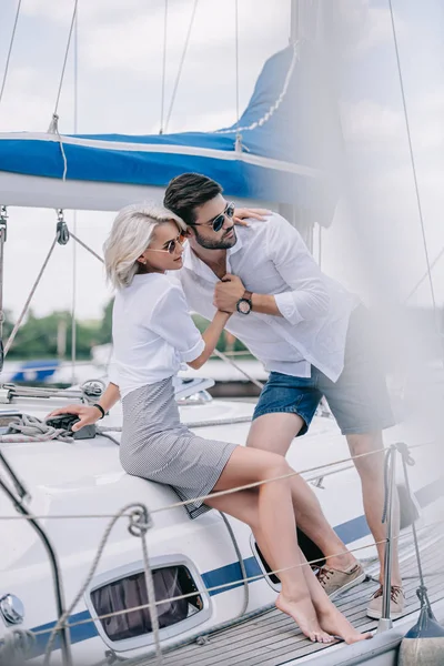 Selektiver Fokus junger verliebter Paare, die sich umarmen und auf Jacht wegschauen — Stockfoto