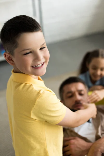 Siblings closing father mouth with black tape at home — Stock Photo