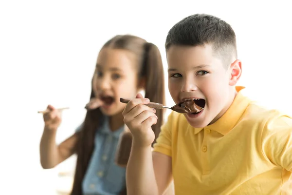 Sister and brother eating chocolate in kitchen — Stock Photo