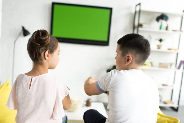 Hermanos jugando videojuego en casa - foto de stock