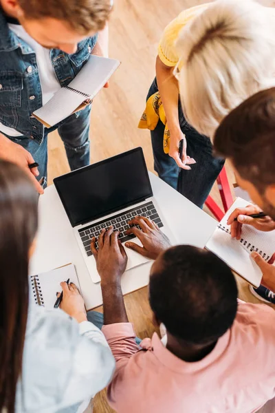 Blick aus der Vogelperspektive auf junge Studenten, die am College gemeinsam Laptop benutzen — Stockfoto