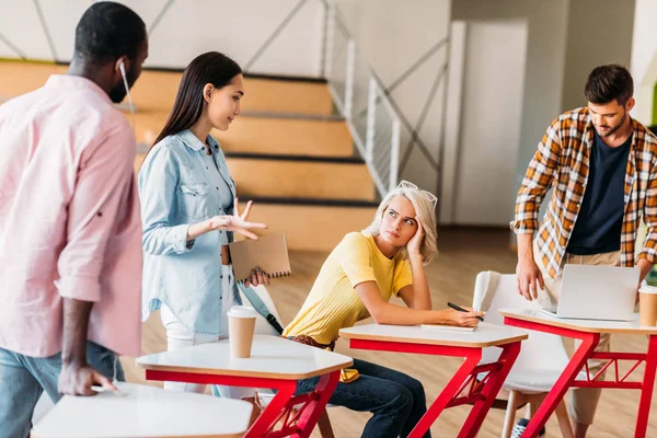 Multiethnic young students spending time together in lecture room of college — Stock Photo