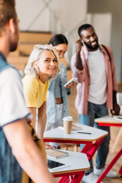 Glückliche junge Studenten verbringen Zeit miteinander im Hörsaal der Hochschule — Stockfoto