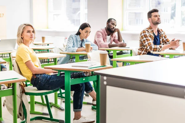 Junge Studenten sitzen während des Unterrichts im Klassenzimmer — Stockfoto