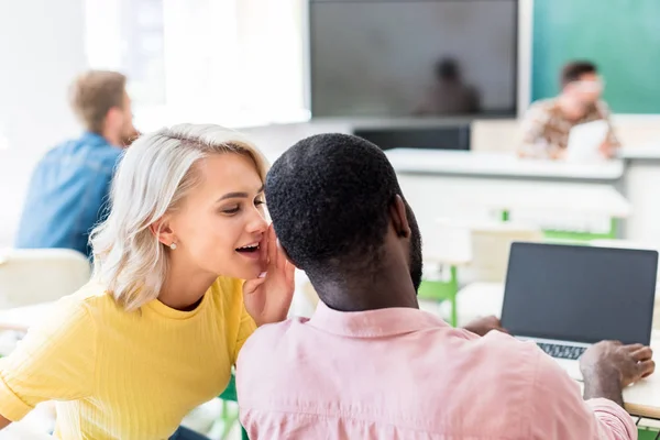 Young students gossiping at classroom during lesson — Stock Photo